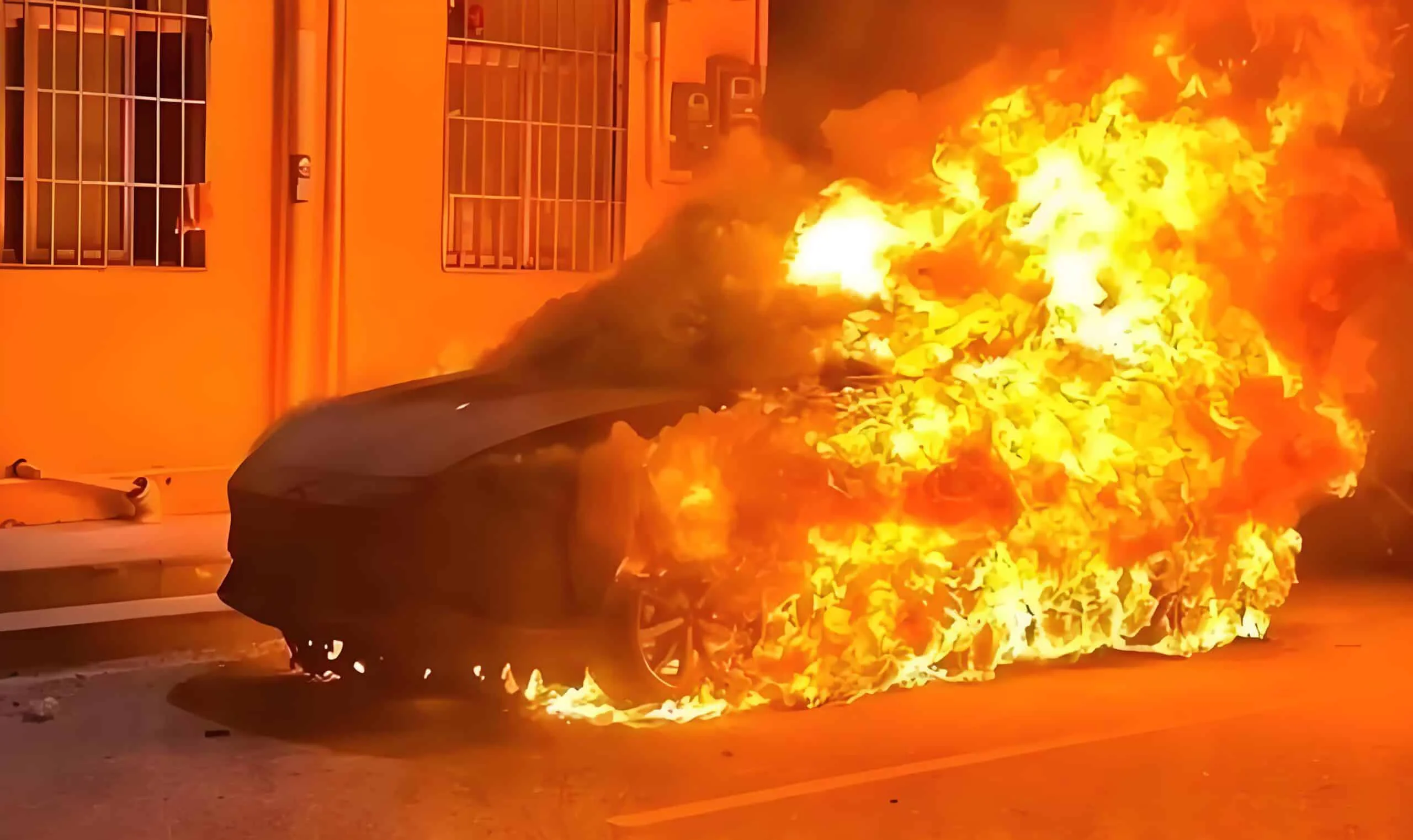 The car is engulfed in raging flames. Such spontaneous combustion often stems from overheated and burnt wiring terminals.
